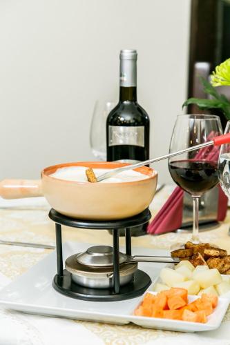 a bowl of food on a stand with a bottle of wine at International Bucharest City Centre Hotel in Bucharest
