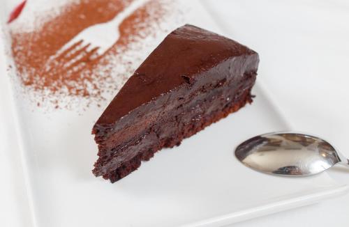 a piece of chocolate cake on a plate with a fork at International Bucharest City Centre Hotel in Bucharest