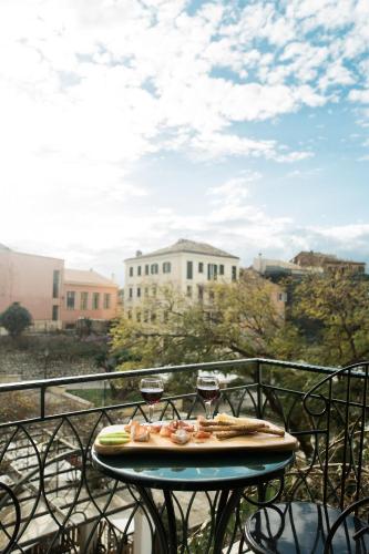 a table with two glasses of wine on a balcony at Deluxe Town Hall Square Flat in Historical Center 2 in Corfu Town