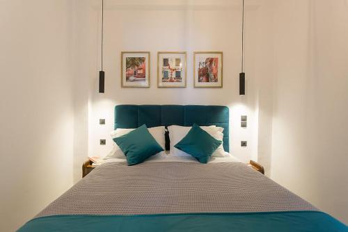 a bedroom with a blue bed with two pillows at Deluxe Town Hall Square Flat in Historical Center 2 in Corfu