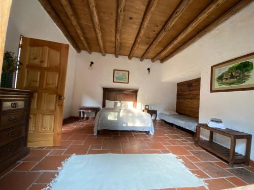 - une chambre avec un lit et un plafond en bois dans l'établissement Hotel Del Rio, à Huasca de Ocampo