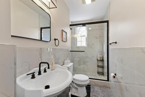 Baño blanco con lavabo y aseo en Casa Soleada in East Rock near DT and Yale SOM with FREE Parking and King Bed, en New Haven
