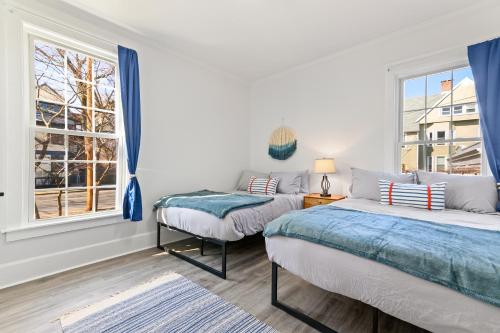 two beds in a room with a window at Casa Soleada in East Rock near DT and Yale SOM with FREE Parking and King Bed in New Haven