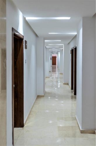 a hallway with white walls and a long hallway with wooden doors at Royal Deluxe Silver - Marrakech, Luxe Pool View in Marrakech