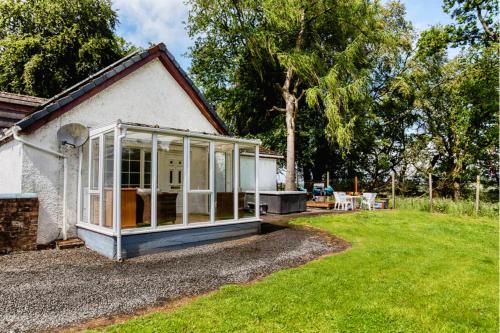 a house with a greenhouse on the side of a yard at Doocot At Bonnyside House - New Hot Tub Aug 2025 in Bonnybridge