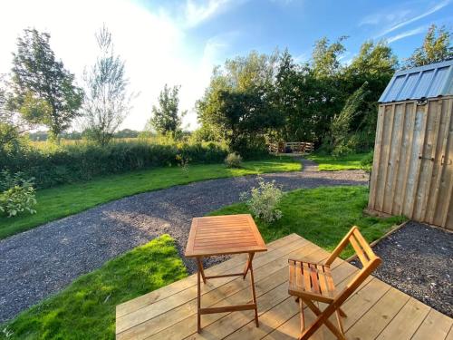 a wooden table and a chair on a wooden deck at Countryside Cabin in Taunton