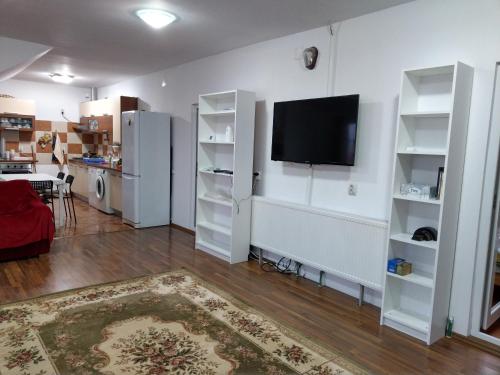 ein Wohnzimmer mit weißen Regalen und einem Flachbild-TV in der Unterkunft Apartament 5 camere cu balcon Costinesti plaja 5 minute Nucilor 6 in Costinești