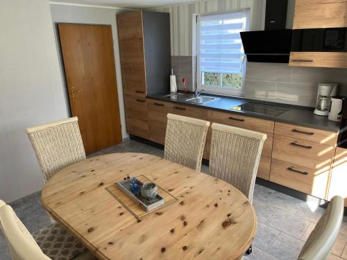 ヴェルドゥムにあるFerienhaus Sonnenschein Heykenのキッチン(木製テーブル、椅子、キッチンカウンター付)