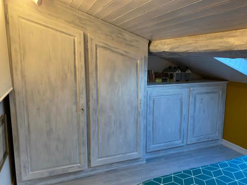 a room with blue cabinets and a wooden ceiling at B&B Insolite entre Lyon et aéroport in Pusignan