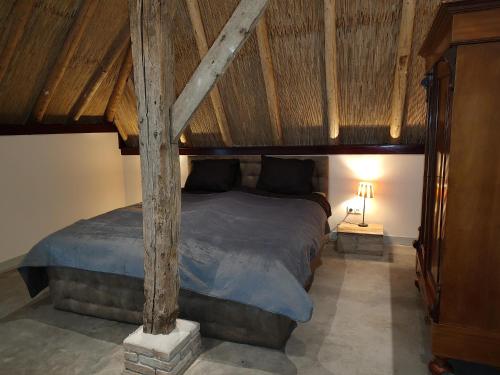 een slaapkamer met een groot bed en een houten plafond bij Juweeltje van vakantiewoning op prachtig landgoed in Nieuwleusen