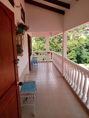 a room with a balcony with chairs and windows at Lago Calima - Bella Finca in Madroñal