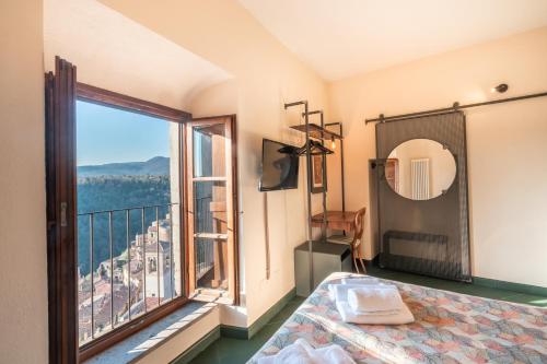 a bedroom with a bed and a large window at Hotel Della Fortezza in Sorano