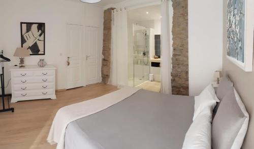 a white bedroom with a bed and a walk in shower at Chambre privée indépendante dans une maison in Néffiès