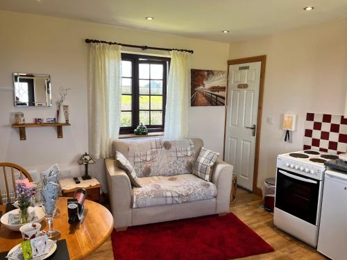 a living room with a couch and a table at Croft View in Helston