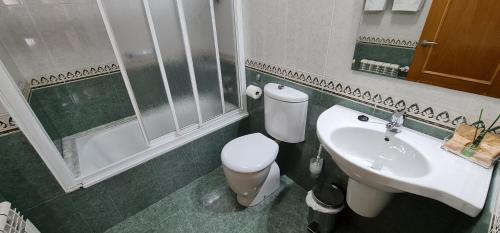 a bathroom with a toilet and a sink at Hotel Casa Benilde in Palas de Rei 