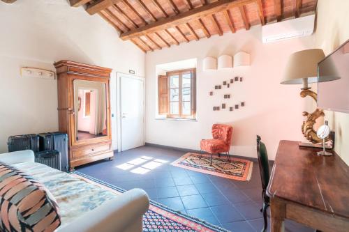 Cette chambre comprend un lit, un bureau et une chaise. dans l'établissement Hotel Della Fortezza, à Sorano