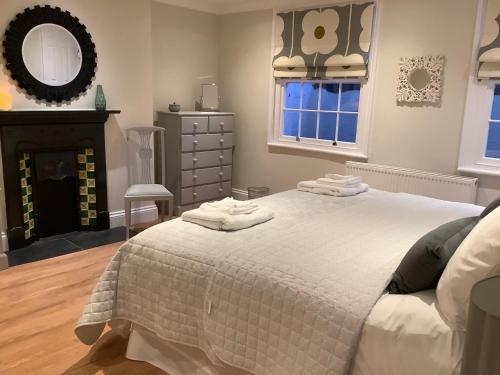 een slaapkamer met een bed met handdoeken erop bij Luxury Refurbished 2 Bedroom Regency Apartment in Cheltenham
