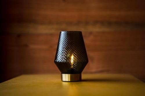 a black lamp sitting on a table in a room at Charmante Cabane dans les arbres avec jacuzzi et sauna in Boismorand