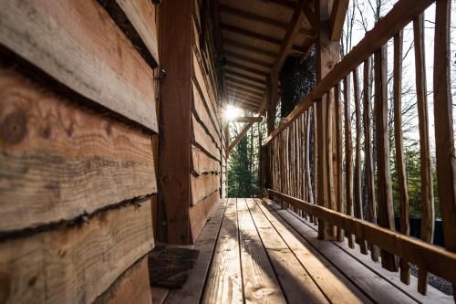 a wooden walkway with a light on the side of a building at Charmante Cabane dans les arbres avec jacuzzi et sauna in Boismorand