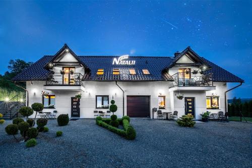 a large white house with a dark roof at Natalii in Kudowa-Zdrój