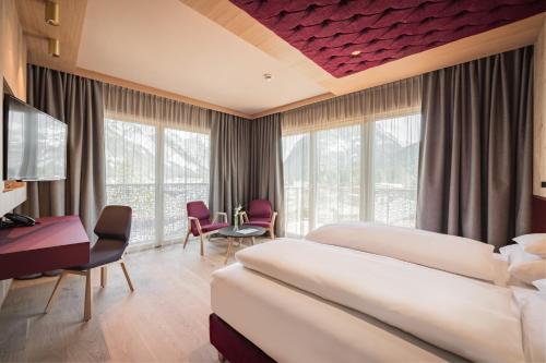 Cette chambre comprend deux lits et un bureau. dans l'établissement Hotel Kristall - Adults only, à Leutasch