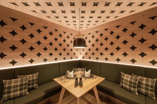 a dining room with a table and a wall with triangles at Hotel Kristall - Adults only in Leutasch