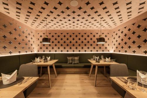 a dining room with two tables and a green bench at Hotel Kristall - Adults only in Leutasch