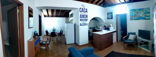 a living room with a blue couch and a kitchen at Casa dos Valentes in Santo Espírito