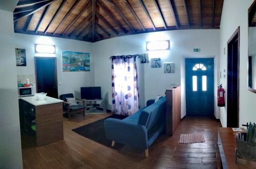 a living room with a blue couch and a table at Casa dos Valentes in Santo Espírito