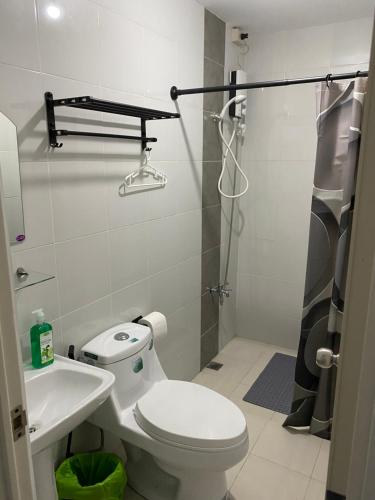 a bathroom with a toilet and a sink and a shower at Victoria Sports Tower in Manila