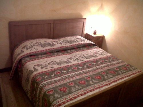a bed with a quilt on it in a bedroom at Alloggio Castello Tesino in Castello Tesino