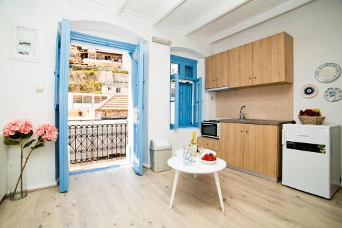 een keuken met een witte tafel en een witte koelkast bij spongkalyA apartment II in Kalymnos