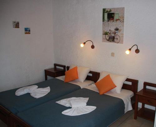 アムーダラ・イラクリオンにあるVioletta Hotelのベッドルーム(ツインベッド2台、オレンジと白の枕付)