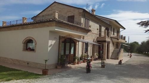 a house with a balcony on top of it at Agriturismo Fonte Carra in Grottazzolina
