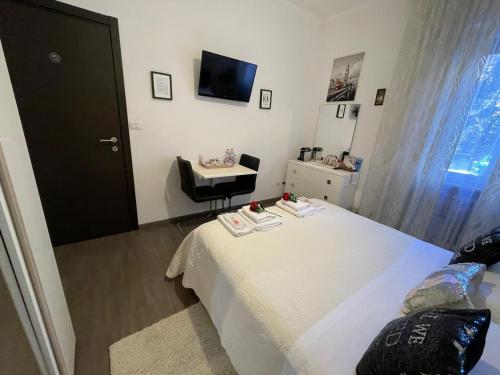 a bedroom with a bed and a table and a television at Appartamento Natalia Verona in Verona