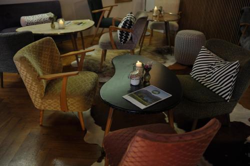 a room with chairs and a table with a candle at Alpenrose Bayrischzell Hotel in Bayrischzell