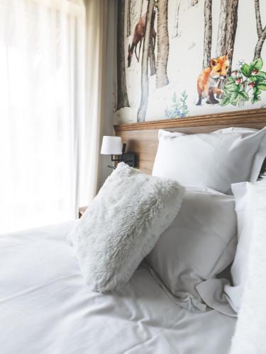 a bed with white sheets and pillows on it at Coloft in Lesquin