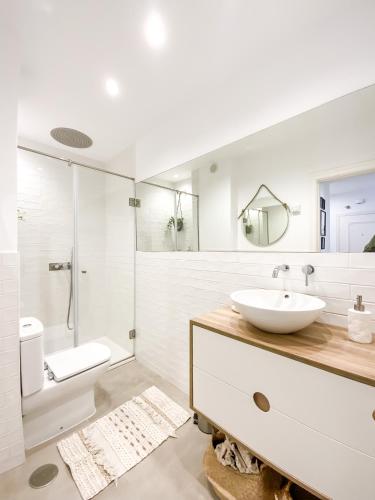 a white bathroom with a sink and a shower at Apartamento Fufú by ALÔGA in Corcubión