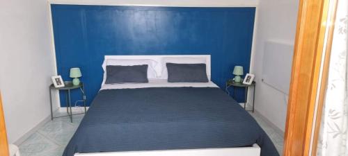 a blue bedroom with a bed with a blue wall at "CASA SUNSET" in Ischia