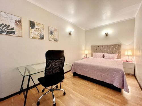 a bedroom with a bed and a desk and a chair at Milne Apartments in Saint Petersburg