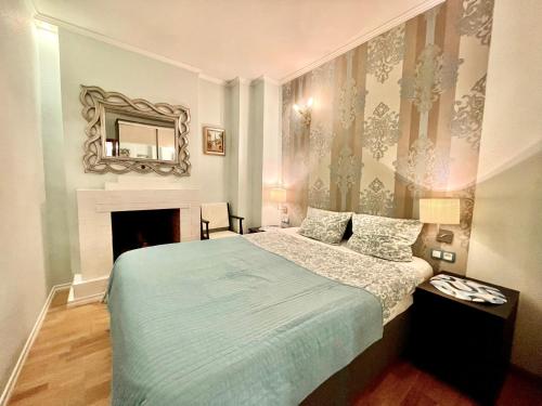 a bedroom with a bed with a fireplace and a mirror at Milne Apartments in Saint Petersburg