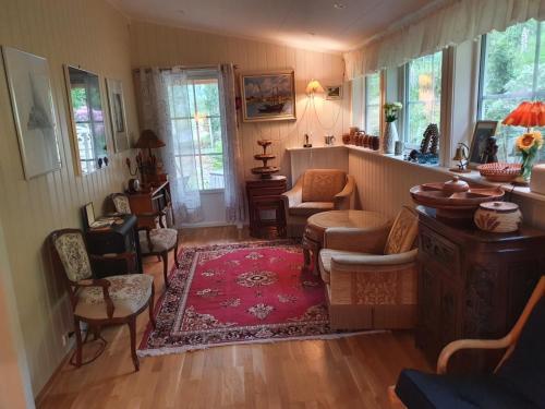 a living room with chairs and a red rug at Sjarmerende feriehus i Olden rett ved fjorden in Stryn