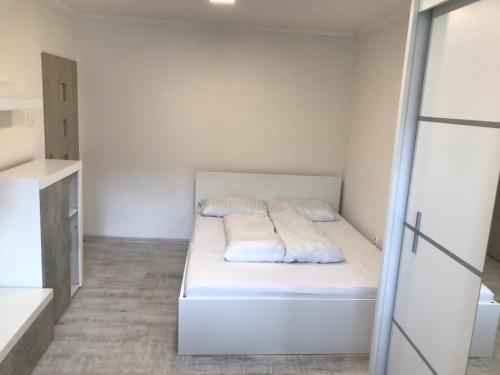 um pequeno quarto branco com uma cama em Apartmán blízko centra em Humenné