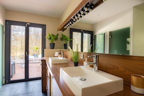 a bathroom with two sinks and a large mirror at Loft Haut de gamme en Champagne in Isles-sur-Suippe