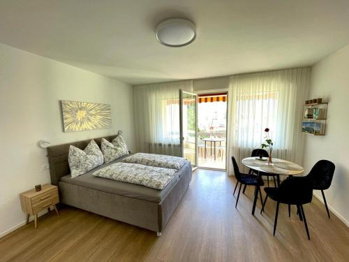 a bedroom with a bed and a table with chairs at Garden Pool Apartment in Merano
