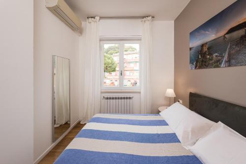 a bedroom with a bed with a blue and white striped blanket at Poseidon Apartment 011019-LT-0180 in Monterosso al Mare