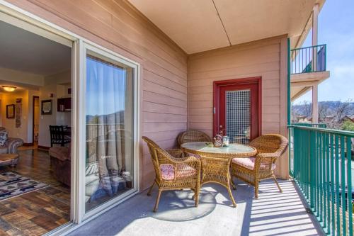 a patio with a table and chairs on a balcony at Gorgeous 2BD 2BTH Condo with Mountain Views Pool Hot Tub Game Room Close to Parkway in Pigeon Forge