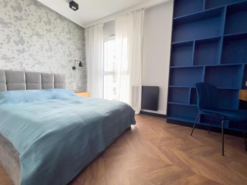 Un dormitorio con una cama y una pared azul. en Mint Apartments Premium Gdynia, en Gdynia