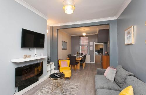 a living room with a couch and a tv at Titanic The Lady, 3 Bed Townhouse in Belfast