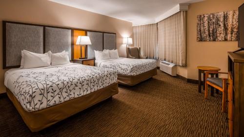a hotel room with two beds and a television at Americinn by Wyndham Birch Run - Frankenmuth in Birch Run